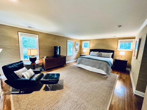 a bedroom with a bed and a couch and a chair at Upmarket Country Retreat, Washington, Connecticut in Washington