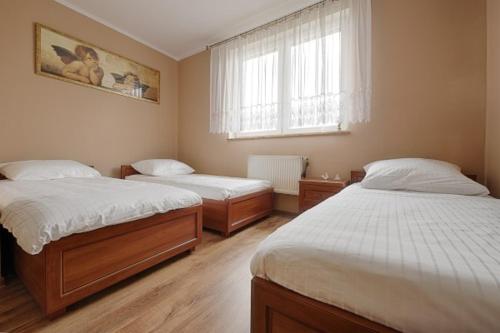 1 dormitorio con 2 camas y ventana en Winnica Mozów, 
