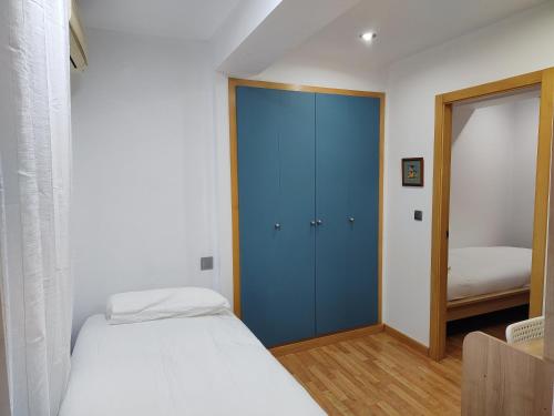 1 dormitorio con armario azul y cama en San Cristobal 2, en Orihuela