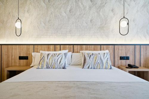 1 dormitorio con 1 cama con 2 luces encima en Bull Vital Suites & Spa Boutique Hotel - Only Adults, en Playa del Inglés