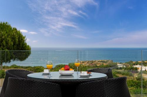 a table with a bowl of fruit and two glasses of orange juice at Sao Rafael Holidays in Albufeira