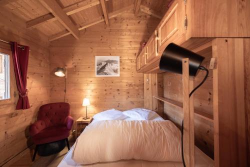 une chambre avec un lit et une chaise rouge dans l'établissement Chalet Chacaltaya, à Chamonix-Mont-Blanc