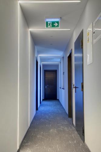 a corridor in an office building with a sign on the ceiling at Avenue21 in Zagreb