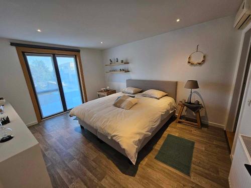 a bedroom with a large bed and a large window at Stadsparel Sint-Truiden in Sint-Truiden
