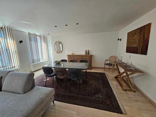 een woonkamer met een tafel en een bank bij Stadsparel Sint-Truiden in Sint-Truiden