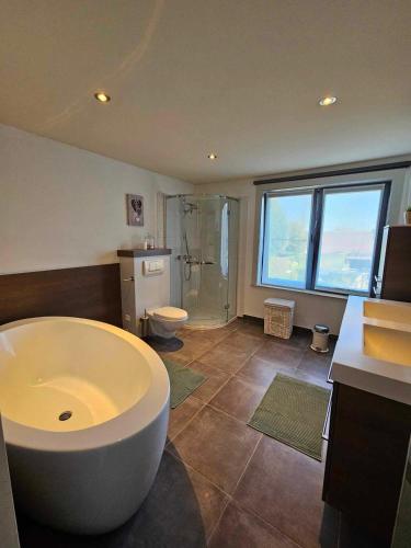 baño grande con bañera grande y aseo en Stadsparel Sint-Truiden, en Sint-Truiden
