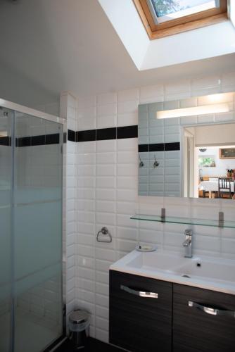 une salle de bain avec un lavabo et une douche en verre dans l'établissement La Ferme du Mesnil - Maison familiale, à Bézu-Saint-Éloi