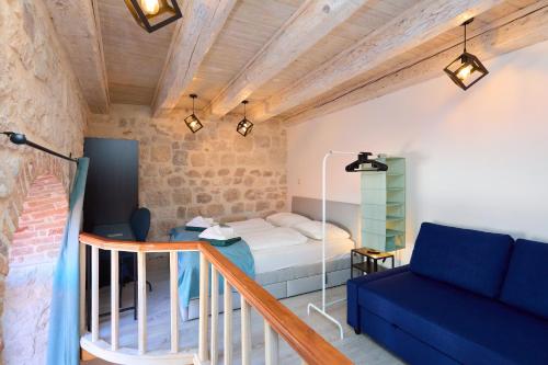 a small room with a bed and a blue couch at Dominium Premium Location Suites in Dubrovnik
