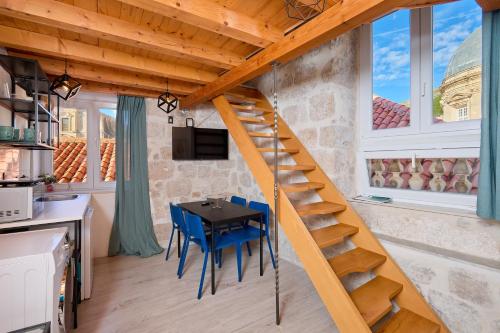 a staircase in a tiny house with a table and chairs at Dominium Premium Location Suites in Dubrovnik
