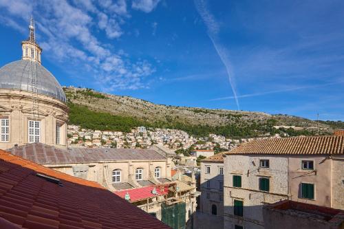 a view of a city with a hill in the background at Dominium Premium Location Suites in Dubrovnik