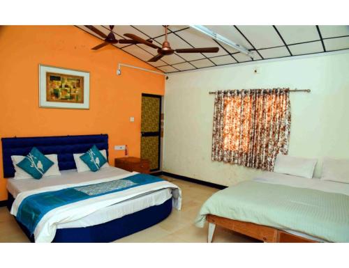um quarto com 2 camas e uma janela em Glorious Gir Resort, Bhojde, Junagadh em Sasan Gir