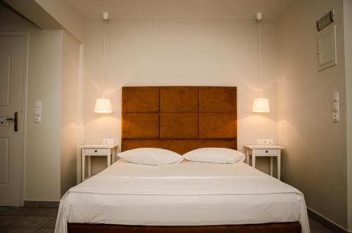 a bed with two white pillows and two tables at Bello Horizonte in Gythio
