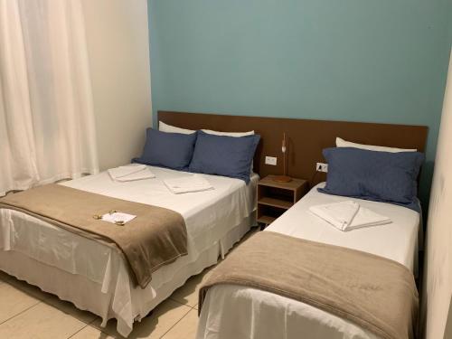 dos camas sentadas una al lado de la otra en una habitación en Pousada Moça Bonita en Ubatuba