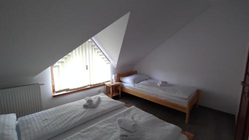 a attic room with two beds and a window at Apartmány Adam in Liptovská Teplá
