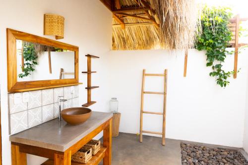 La salle de bains est pourvue d'un lavabo en bois et d'un miroir. dans l'établissement Still Salty Escape, à El Viejo
