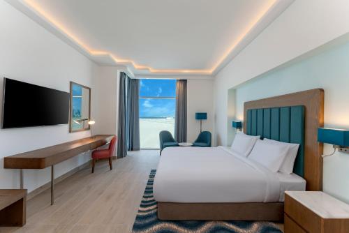 ドバイにあるPark Regis by Prince Dubai Islandsのベッドとデスクが備わるホテルルームです。
