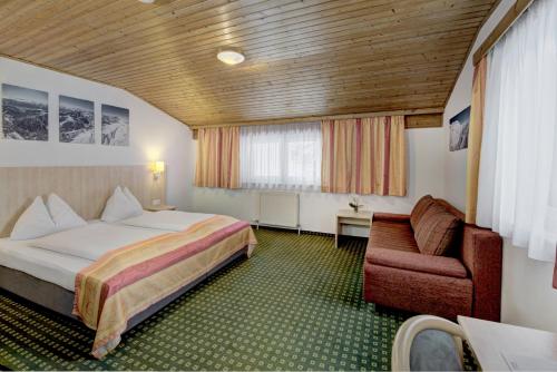 ein Hotelzimmer mit einem Bett und einem Stuhl in der Unterkunft Hotel-Restaurant Bike&Snow Lederer in Mühlbach am Hochkönig