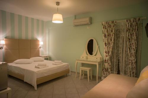 a bedroom with two beds and a table and a mirror at Bello Horizonte in Gythio