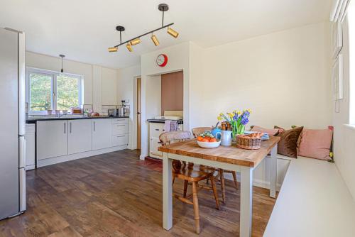 uma cozinha e sala de estar com uma mesa de madeira num quarto em Hangley Cottage em Minehead