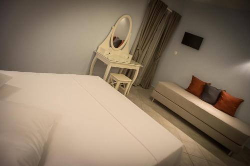 a bedroom with a bed and a mirror and a couch at Bello Horizonte in Gythio