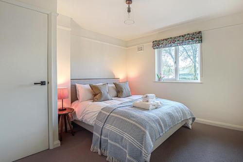 um quarto com uma cama e uma janela em Hangley Cottage em Minehead