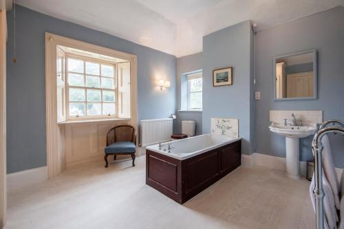 ein Badezimmer mit einer Badewanne und einem Waschbecken in der Unterkunft Emmetts Grange House in Minehead