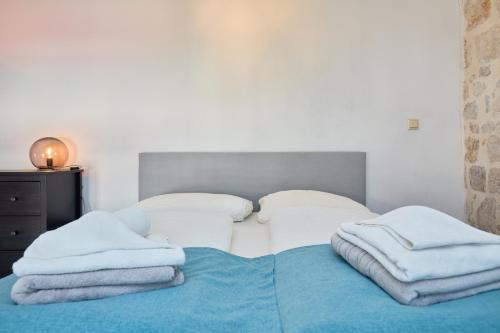 a bedroom with a bed with towels on it at Dominium Premium Location Suites in Dubrovnik