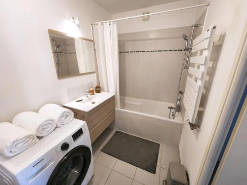 y baño blanco con lavadora. en Bel Appartement avec Terrasse et Clim, en Montpellier