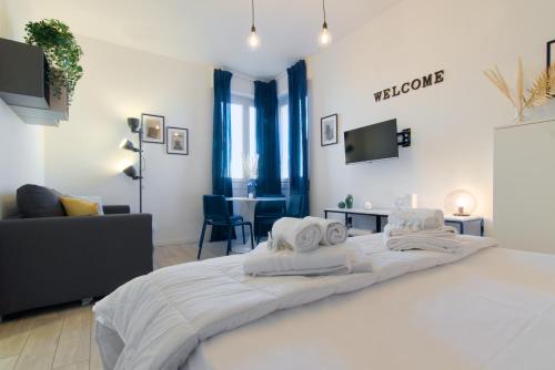 a bedroom with a large white bed with towels on it at Sesto Sky Design - Sesto Rondò in Sesto San Giovanni