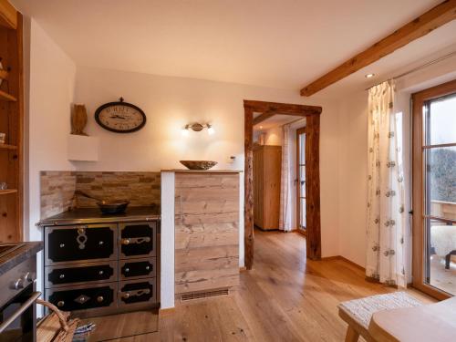 eine Küche mit Holzböden und einer Uhr an der Wand in der Unterkunft Apartment-Chalet Mödlinghof in Hopfgarten im Brixental