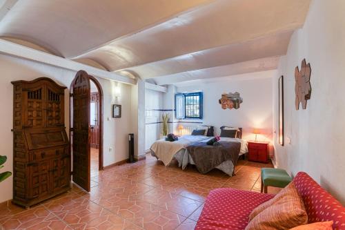 um quarto com uma cama e um sofá num quarto em Casa Lola Callosa em Callosa de Ensarriá