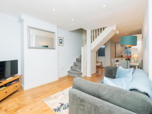a living room with a couch and a staircase at Delightful retreat in Larkhall with free parking - Pass the Keys in Bath