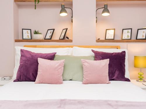 a bedroom with purple and white pillows on a bed at Delightful retreat in Larkhall with free parking - Pass the Keys in Bath