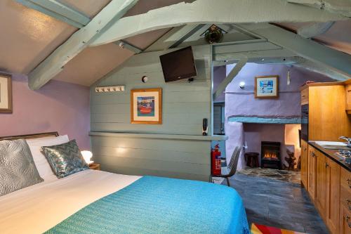 1 dormitorio con 1 cama en una habitación con chimenea en Finest Retreats - Fishermans Cottage, en Tintagel