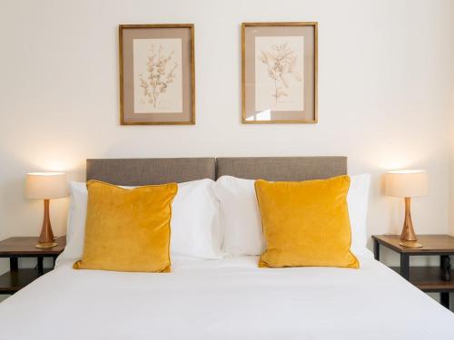 a bedroom with a white bed with yellow pillows at Pass the Keys Stunning 2 bed retreat in the heart of Bath in Bath