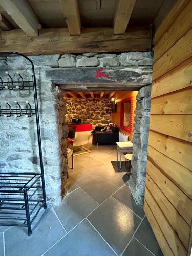 a living room with a stone wall and a staircase at Chalet La Léchère in Valmeinier