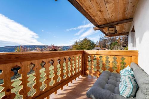 a balcony with a couch on a wooden deck at Historisches Apartment Duregghof in San Genesio Atesino