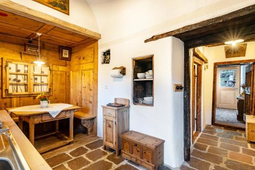 a kitchen with wooden walls and a table and a sink at Historisches Apartment Duregghof in San Genesio Atesino