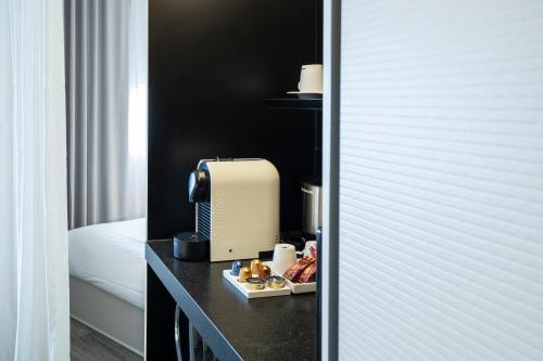 a hotel room with a coffee maker on a table at Novotel Suites Luxembourg in Luxembourg