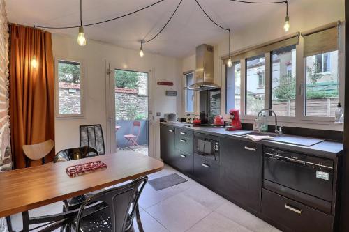 uma cozinha com uma mesa de madeira e uma bancada em Garden Hotel Rennes Centre Gare em Rennes