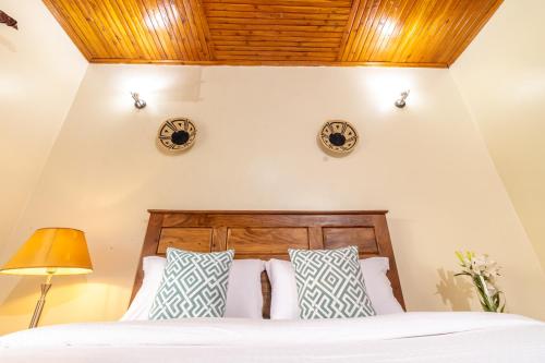 a bedroom with a bed and two clocks on the wall at Nilescape Residence in Jinja