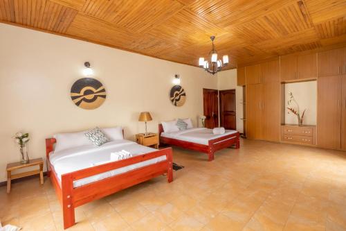 金賈的住宿－Nilescape Residence，一间卧室设有两张床和木制天花板