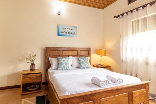 1 dormitorio con 1 cama con toallas en Nilescape Residence, en Jinja
