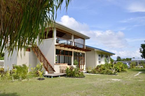 ガンにあるNazaki Beach Hotel & Spa Maldivesの前にヤシの木がある家