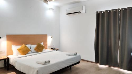 1 dormitorio con 1 cama grande con almohadas amarillas en Krishna palace, en Chennai