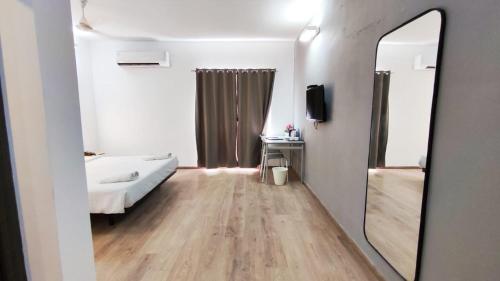 1 dormitorio con cama blanca y espejo en Krishna palace, en Chennai