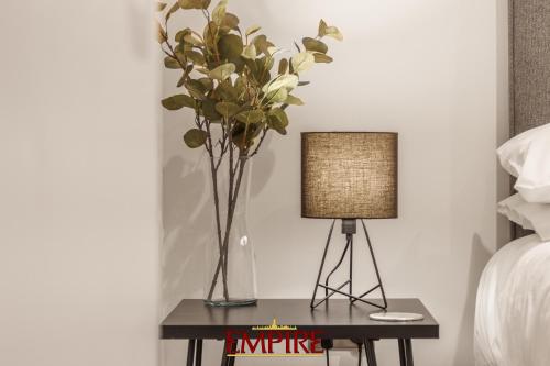 une table avec un vase de fleurs et une lampe dans l'établissement Stylish 2 Bed Apartment Burton On Trent, à Burton-on-Trent