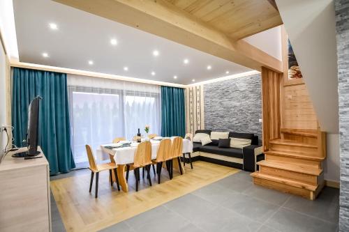 a dining room with a table and a couch at Magiczny Domek in Białka Tatrzanska