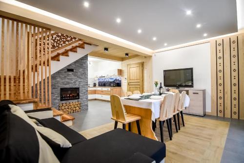 a dining room with a table and a fireplace at Magiczny Domek in Białka Tatrzanska