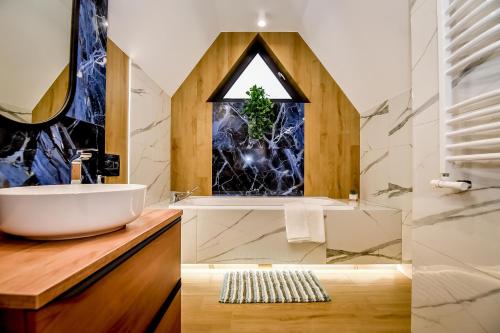 łazienka z umywalką, wanną i oknem w obiekcie Magiczny Domek w mieście Białka Tatrzanska
